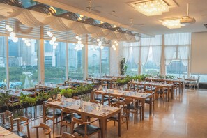 A spacious restaurant with high ceilings, large windows, and modern chandeliers. Tables are neatly arranged with plants and city views. - Hotel Lake (Seoul)