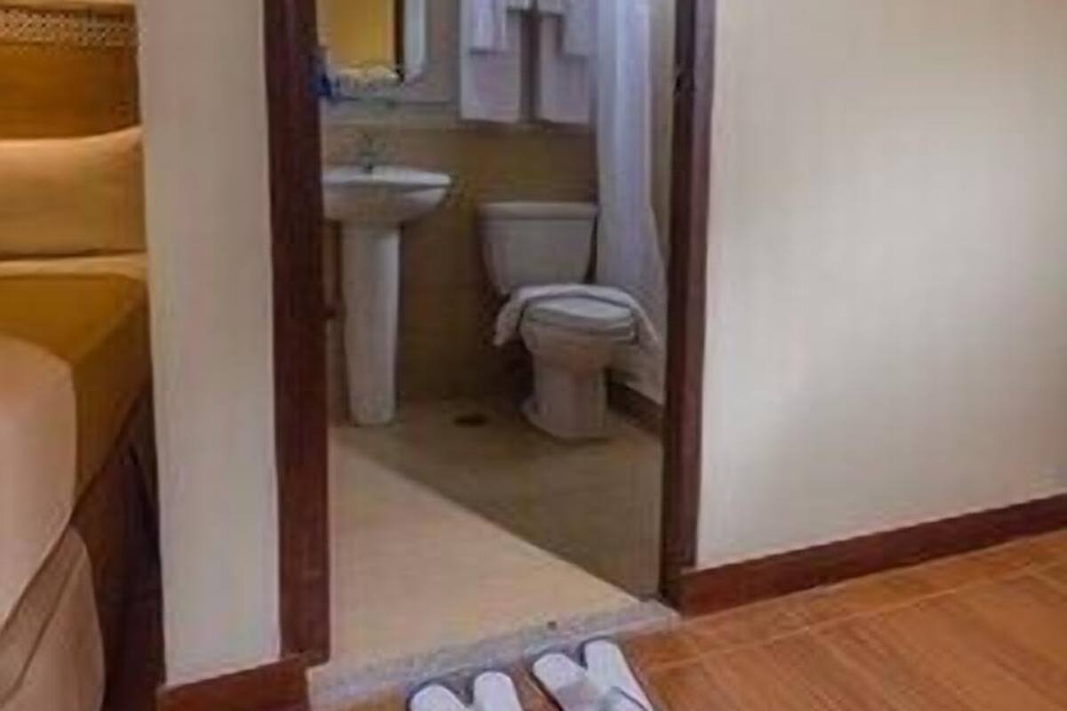 Ein Durchgang zu einem Badezimmer mit Toilette, Waschbecken und Duschvorhang.