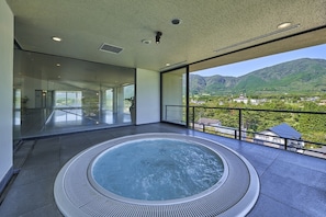 Una bañera caliente moderna con vistas panorámicas a un paisaje montañoso.