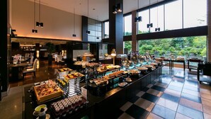 Zona de bufé con diferentes alimentos y un área de asientos con sillas y mesas.