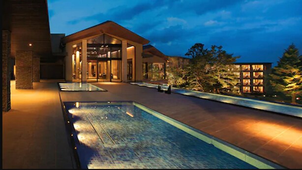 A modern hotel with a large pool, a covered entrance, and a well-lit facade. - Hotel Harvest Nasu (Nasu)