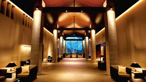 A spacious corridor with high ceilings and large columns, leading to a central area with seating and a view of the outdoors. - Hotel Harvest Nasu (Nasu)
