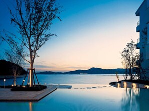 An infinity pool with a clear view of the sea and distant mountains. - Hotel Harvest Hamanako (Hamamatsu)