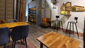 A cozy room with a wooden table, two chairs, a sofa, and a bookshelf. - Pon Pon Woo (Kaohsiung)