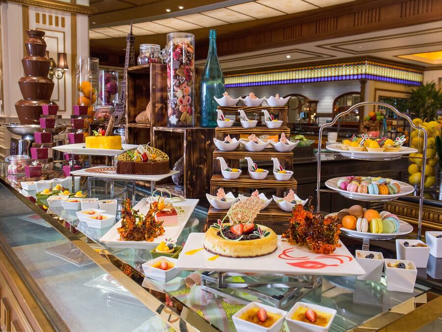 Un buffet proposant une variété de plats et de desserts présentés sur des tables en verre.