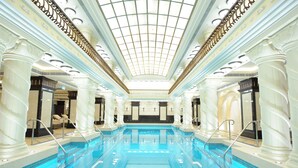 A large indoor swimming pool with a high ceiling and classical architectural columns. - Harbourview Hotel Macau (Macau)