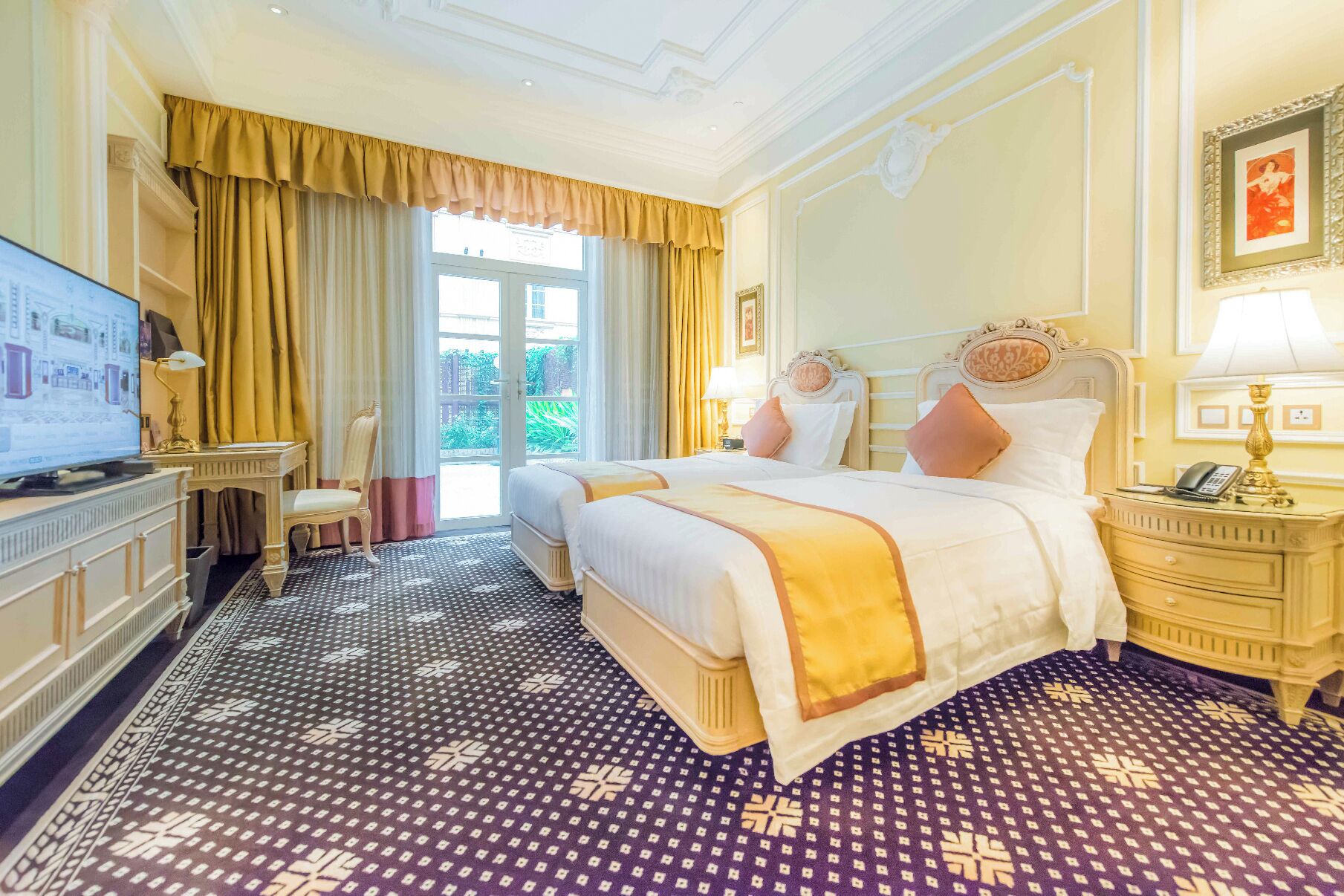 A hotel room with a large bed, a desk, a chair, a television, and a view of the outdoors.