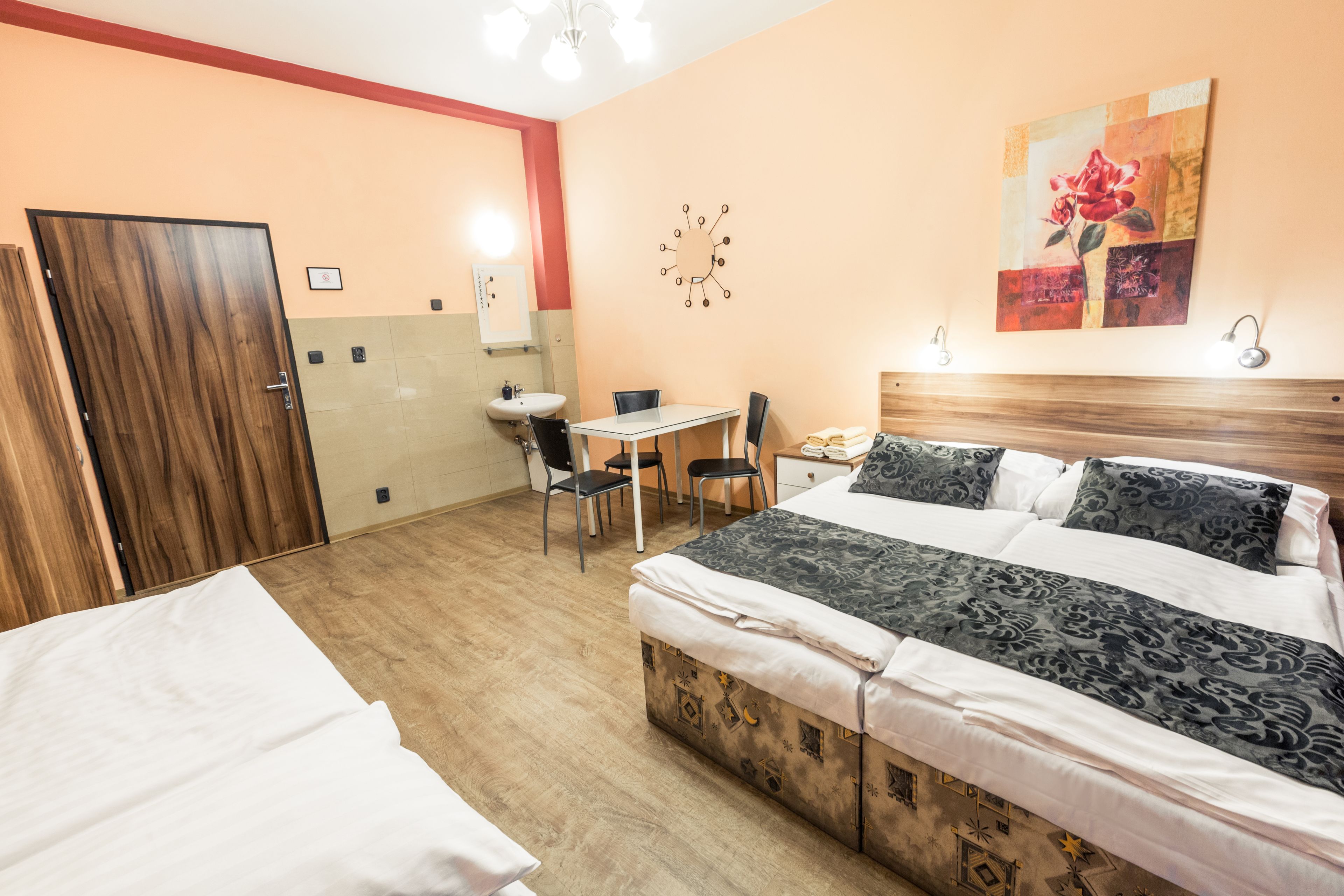 Una habitación de hotel con cama, escritorio, silla, una mesita y armario.