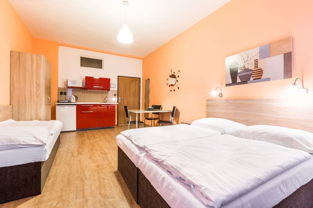 Une chambre d’hôtel avec deux lits, une kitchenette, une table à manger et un petit coin salon.