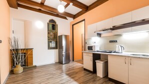 A modern kitchen with wooden flooring, built-in appliances, and a bright overhead light. - Rezidence Davids (Prague)