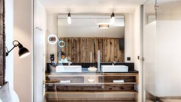 Un bagno moderno con uno specchio grande, due lavabi e un mobile contenitore in legno.