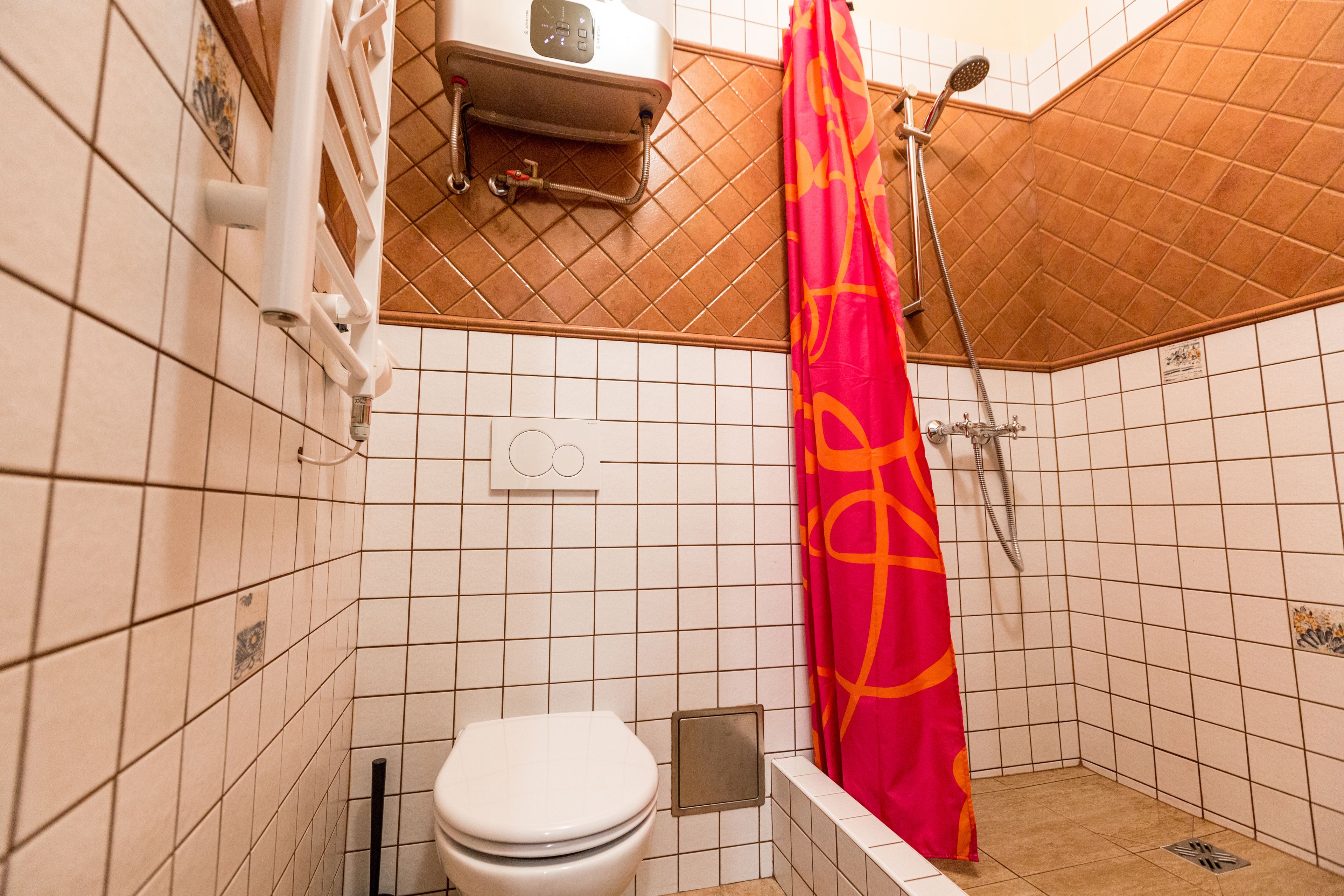 A small bathroom with a toilet, a shower, and a towel rack.