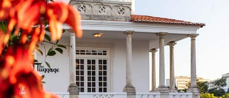 Un edificio con facciata bianca, colonne e un balcone.