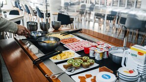 Una mesa de buffet con diversos alimentos y salsas.