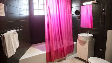 A bathroom with a bathtub, a sink, a toilet, and a shower curtain.