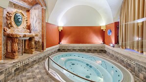 A spa area with a hot tub, ornate wall decor, and a tiled floor. - Hoffmeister Depandance (Prague)