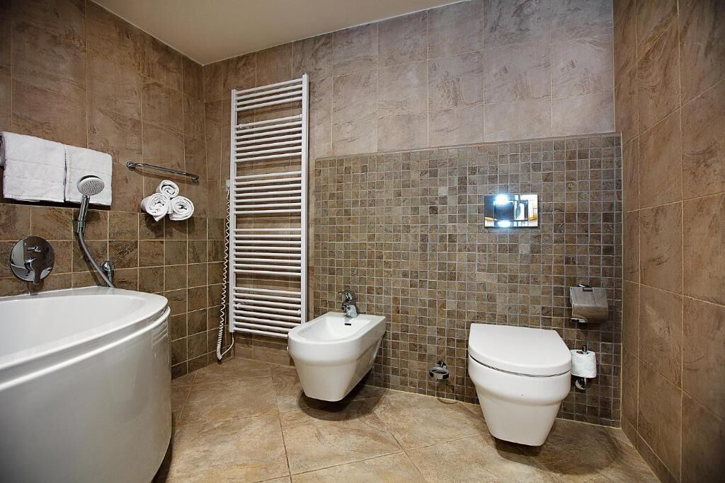 Ein Badezimmer mit Badewanne, Bidet, Toilette und Handtuchhalter.