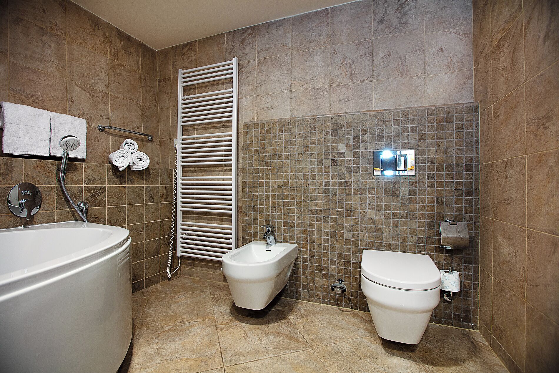 Ein Badezimmer mit Badewanne, Bidet und Toilette.