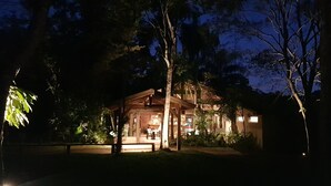 Una cabaña de madera con un espacio de patio, rodeada de árboles.