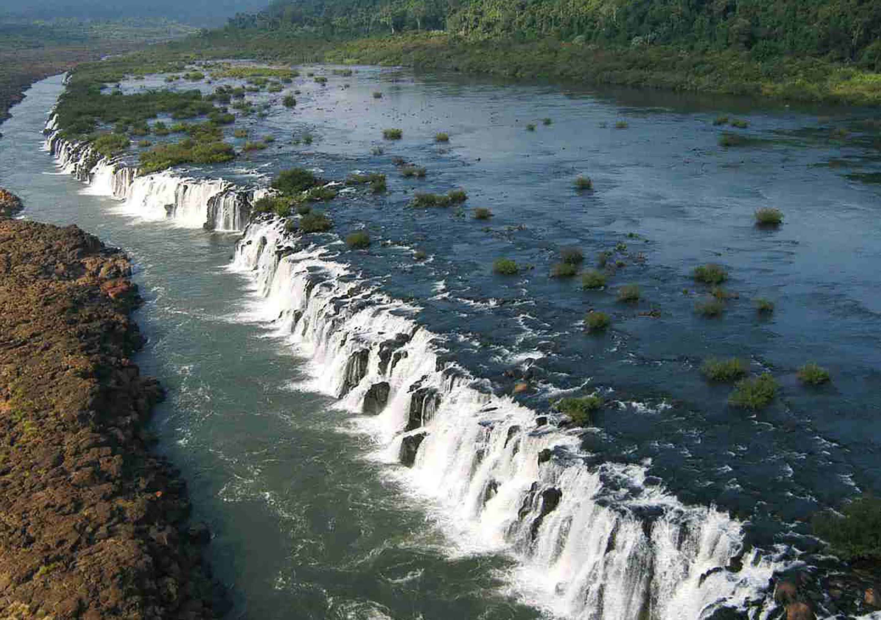 Un fiume con diverse cascate e vegetazione circostante.