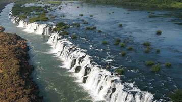 Un fiume con diverse cascate e vegetazione circostante.