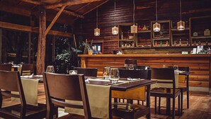 Un restaurante acogedor con mobiliario de madera y una zona de bar.