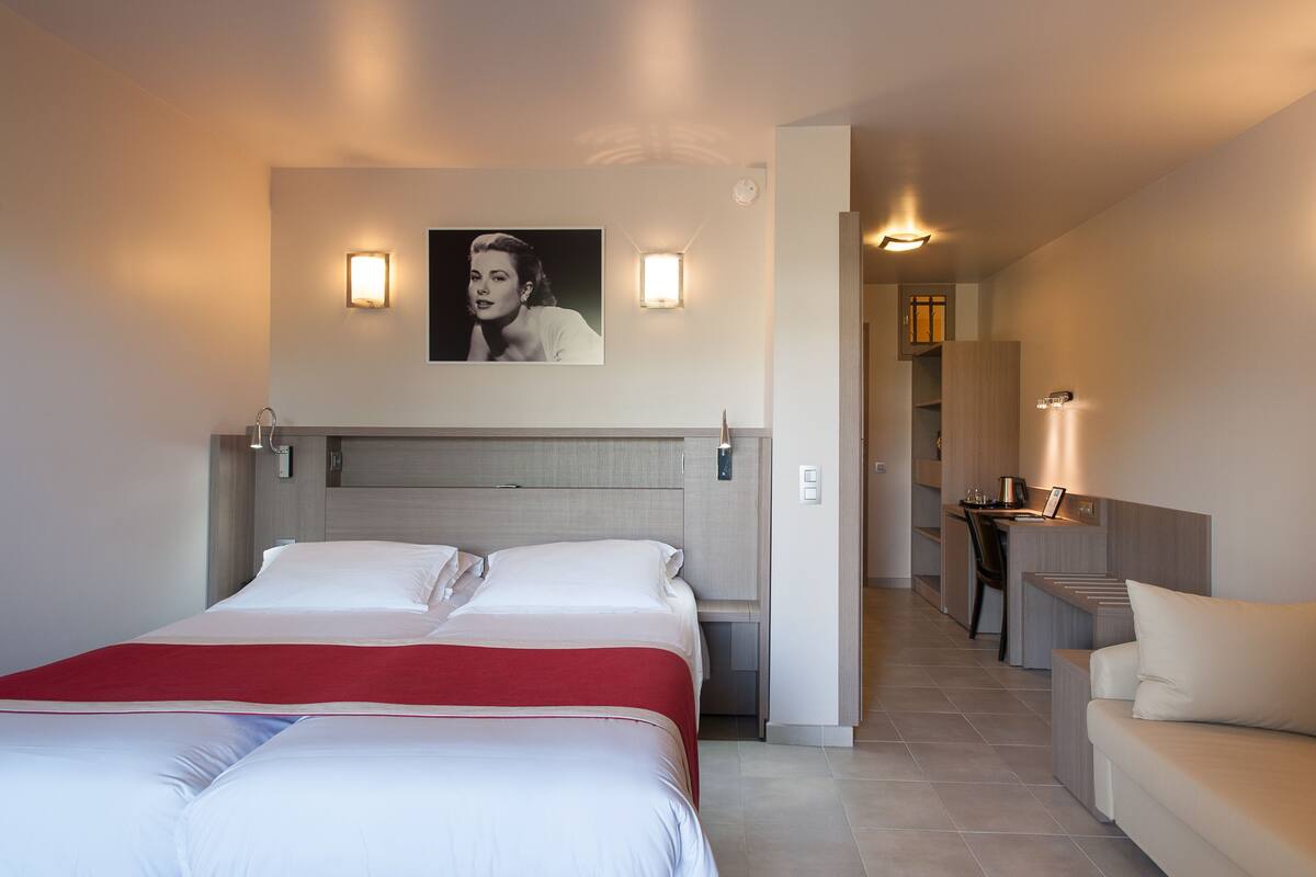 Habitación de hotel con dos camas, una sala de estar y kitchenette.