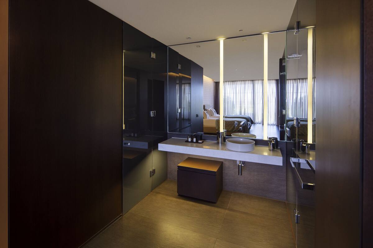 A modern bathroom with a large mirror, a sink, and a vanity.