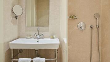 Een moderne badkamer met een wastafel, spiegel en douche.