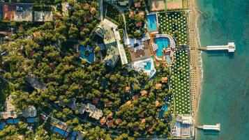 Vista aérea de un resort con varias piscinas, una zona de playa y un muelle.