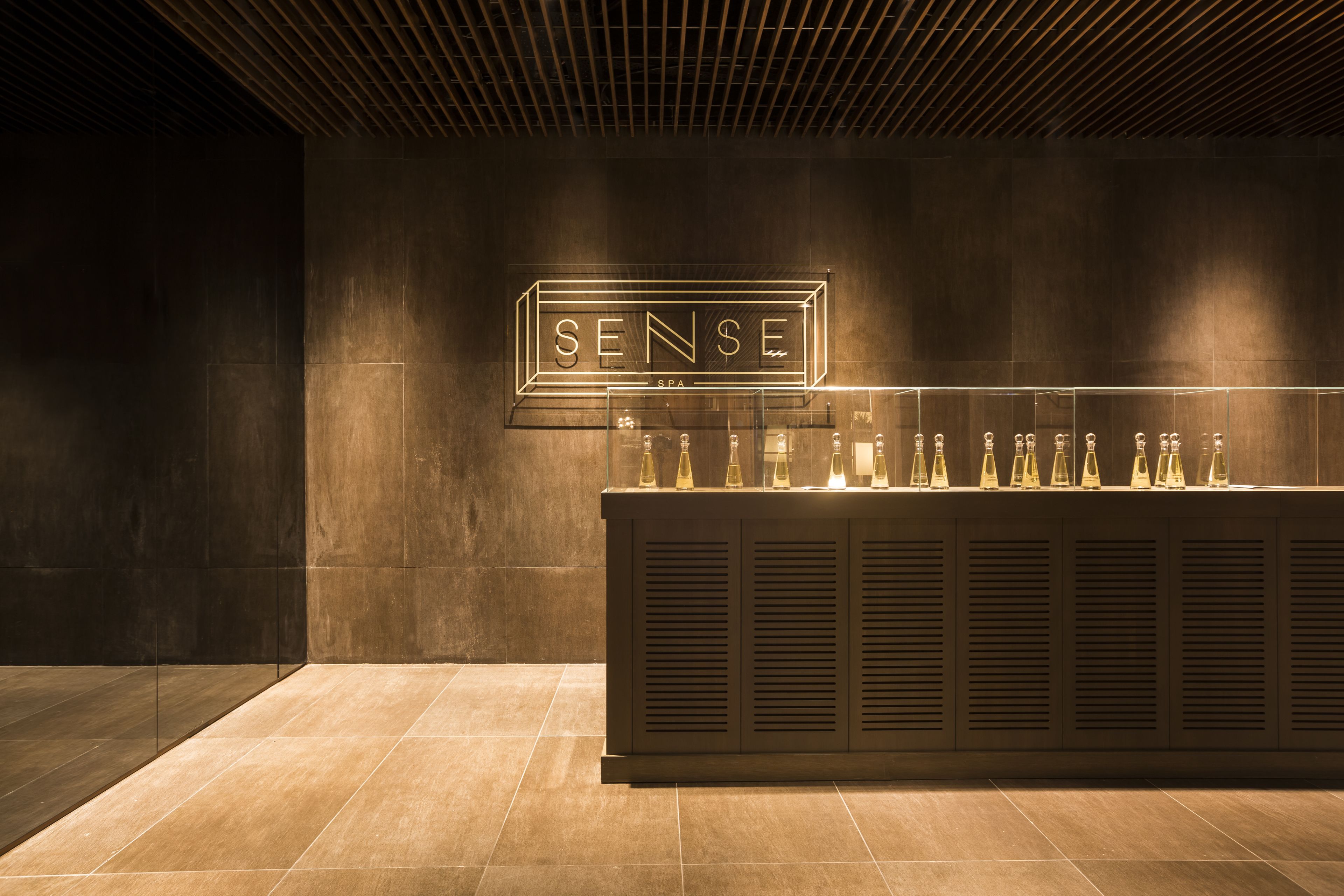 A modern bar area with a sign reading "SENSE SPA" and a row of bottles on display.