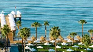 A resort with a pool area, palm trees, and beach chairs. - Voyage Sorgun (Manavgat)
