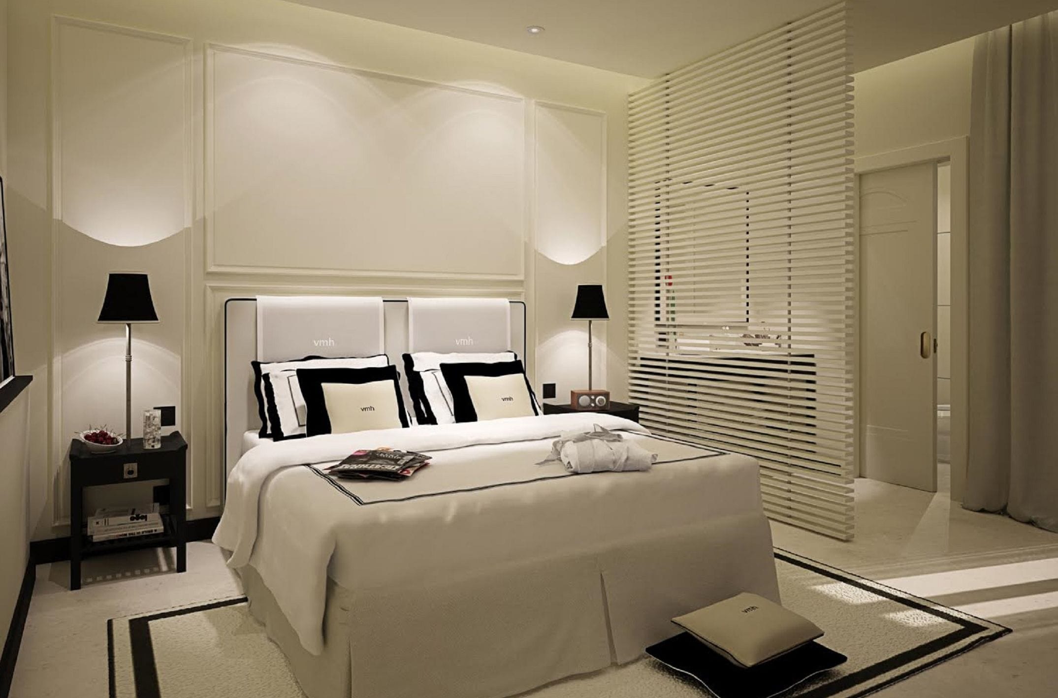 Een moderne hotelkamer met een groot bed, bedlampen, een flatscreen televisie en een nachtkastje met een schaal fruit.