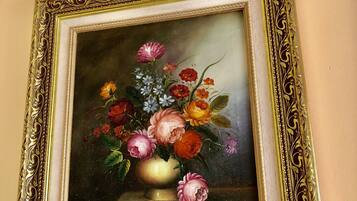 A framed painting of a still life with flowers and a vase.
