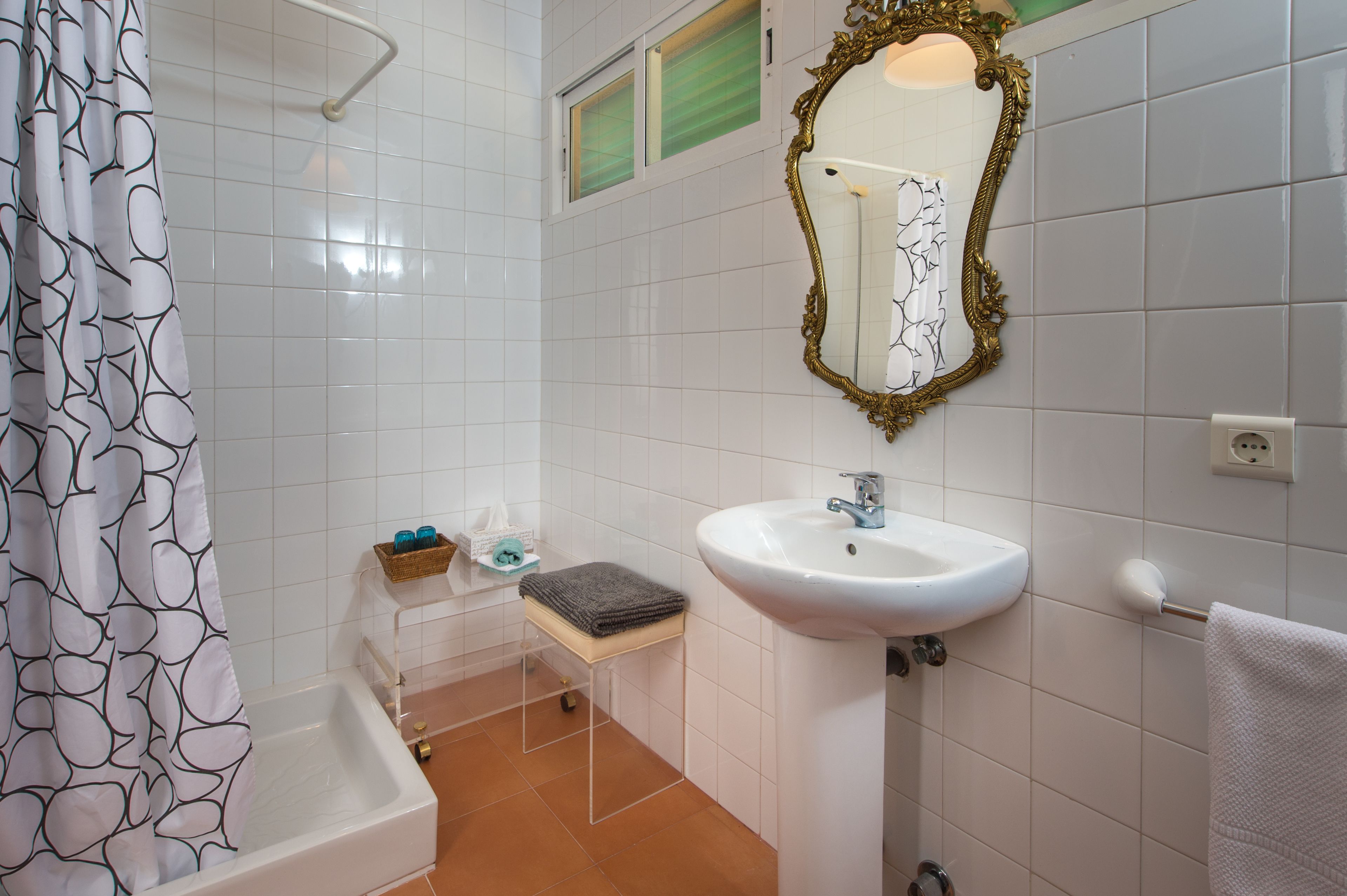 A bathroom with a bathtub, a sink, a mirror, and a towel rack.