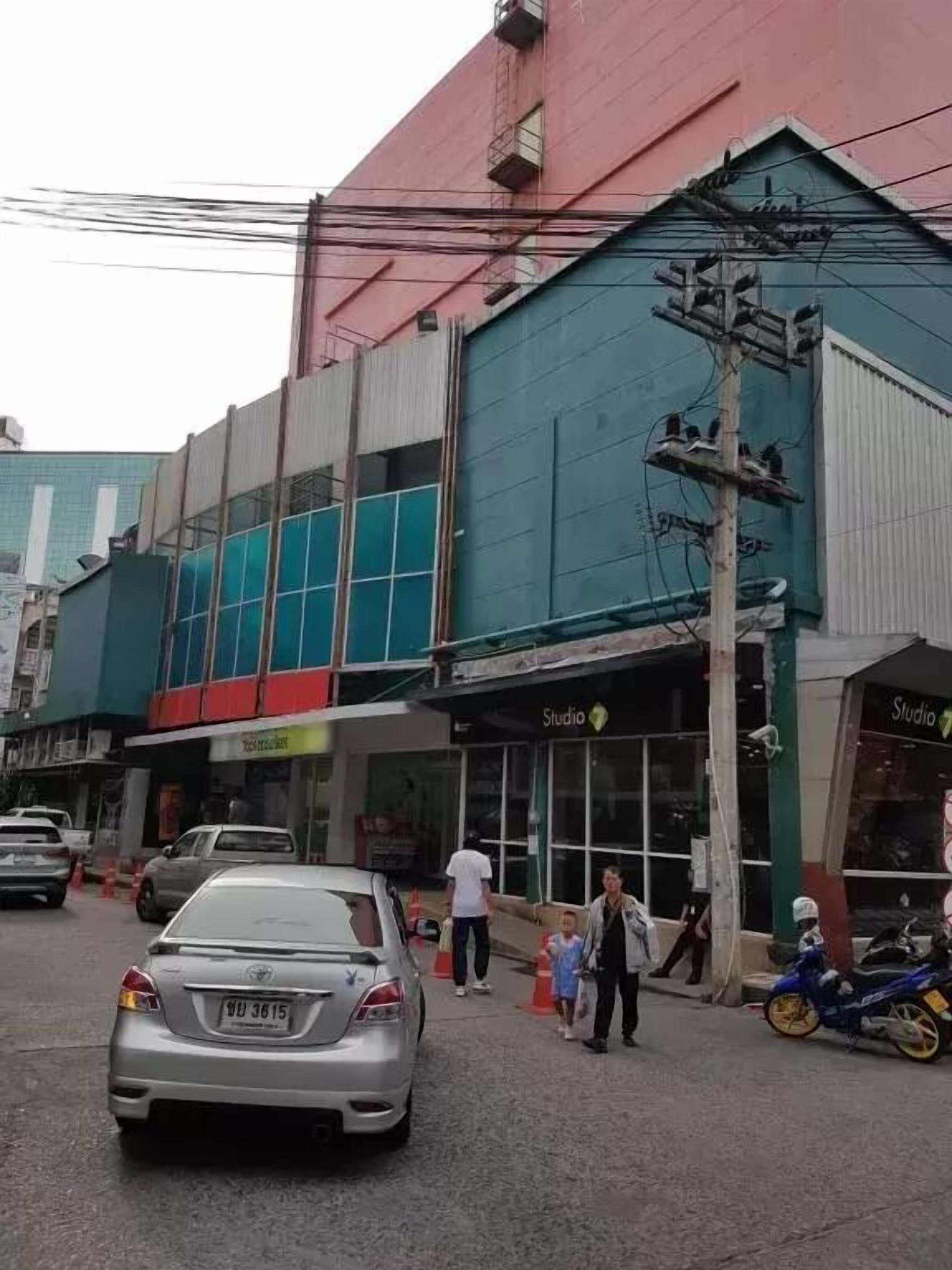 A building with a storefront labeled "Studio" and a parked car in front.
