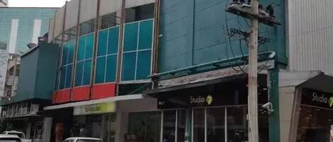 A building with a storefront labeled "Studio" and a parked car in front.