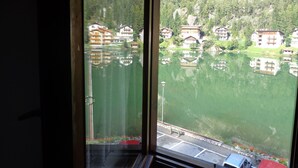 A view of a lake with buildings reflected on the water. - Garnì Astor (Alleghe)