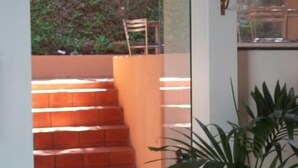 Un escalier menant à un balcon d’où l’on peut admirer la verdure.