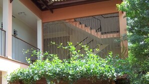 Un bâtiment à deux étages doté d’un espace extérieur abrité, d’un escalier et d’un petit élément décoratif aquatique.