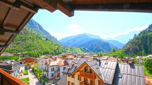 A mountain village with traditional wooden houses, a central square, and a view of the surrounding mountains. - Hotel Venezia (Rocca Pietore)