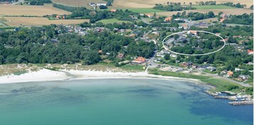 Oversigtsbillede af en kystby med strand, huse og et afgrænset område af interesse.