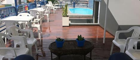 Una piscina al aire libre, sillones reclinables de piscina