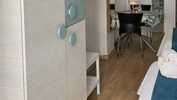 Un dormitorio con cama, armario, escritorio y silla.