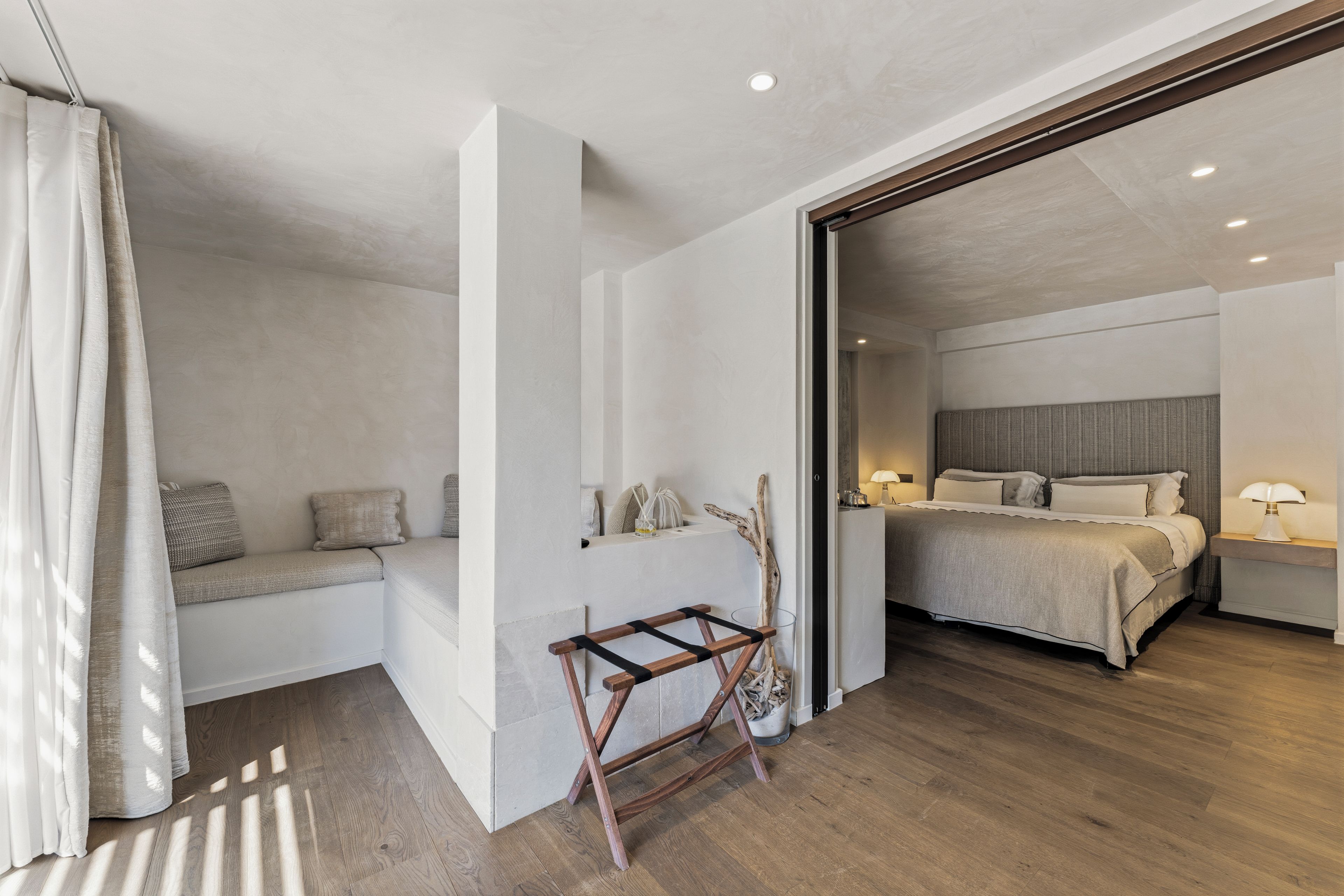 A modern bedroom with a bed, bedside tables, and a bench.