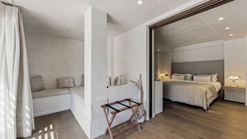 A modern bedroom with a bed, bedside tables, and a bench.
