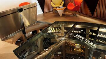 Un interior moderno con una escalera de cristal que lleva a una bodega de vinos.
