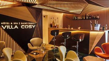 A modern bar area with wooden paneling and bar stools.