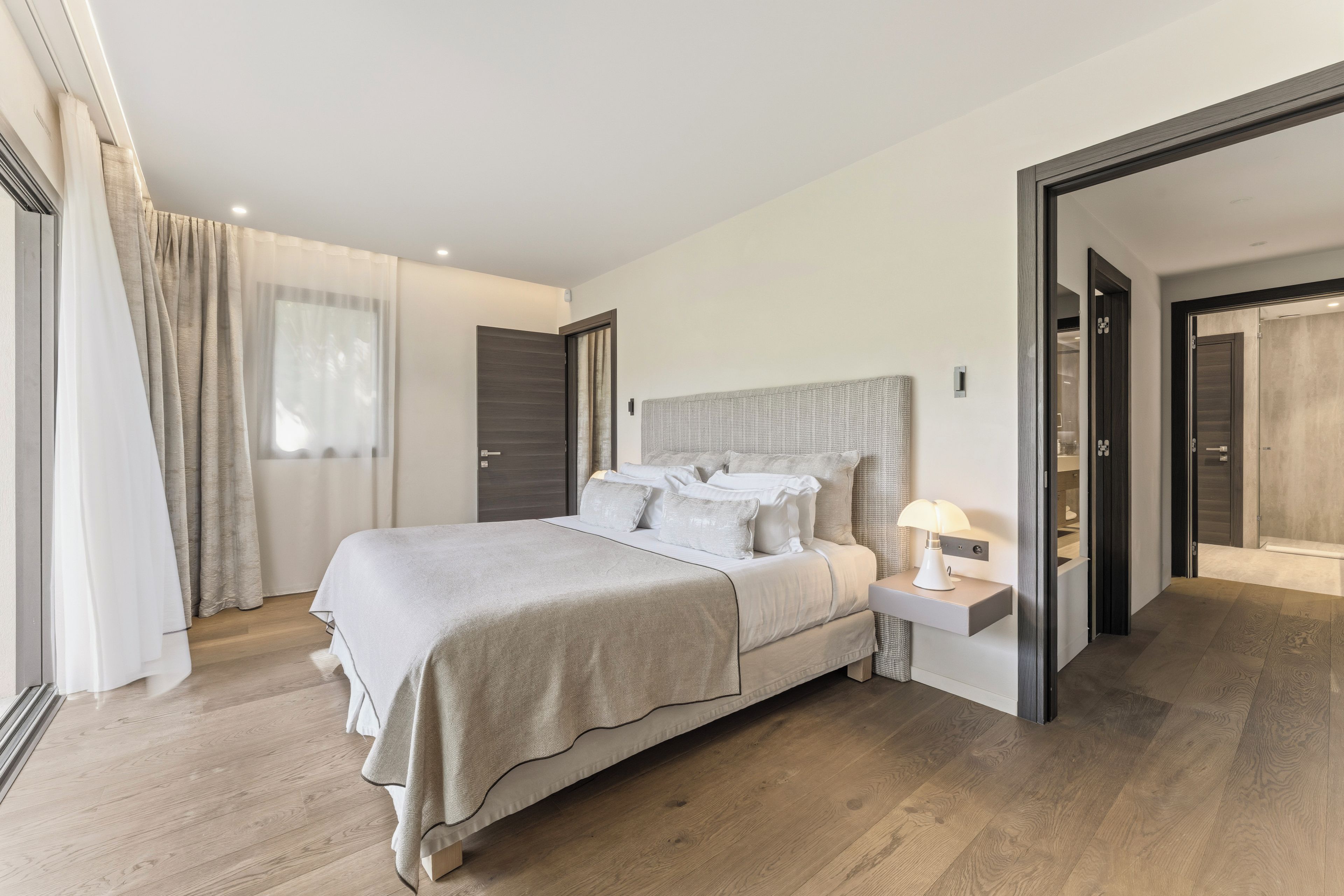 Quarto moderno com cama grande, mesas de cabeceira e closet espaçoso.