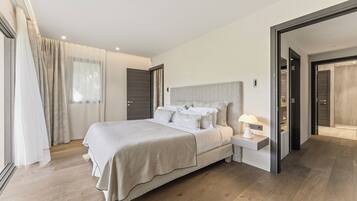 Quarto moderno com cama grande, mesas de cabeceira e closet espaçoso.